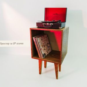 Wooden cube-style cabinet with a turntable on top and LPs stored inside the lower compartment, set against a pale background.