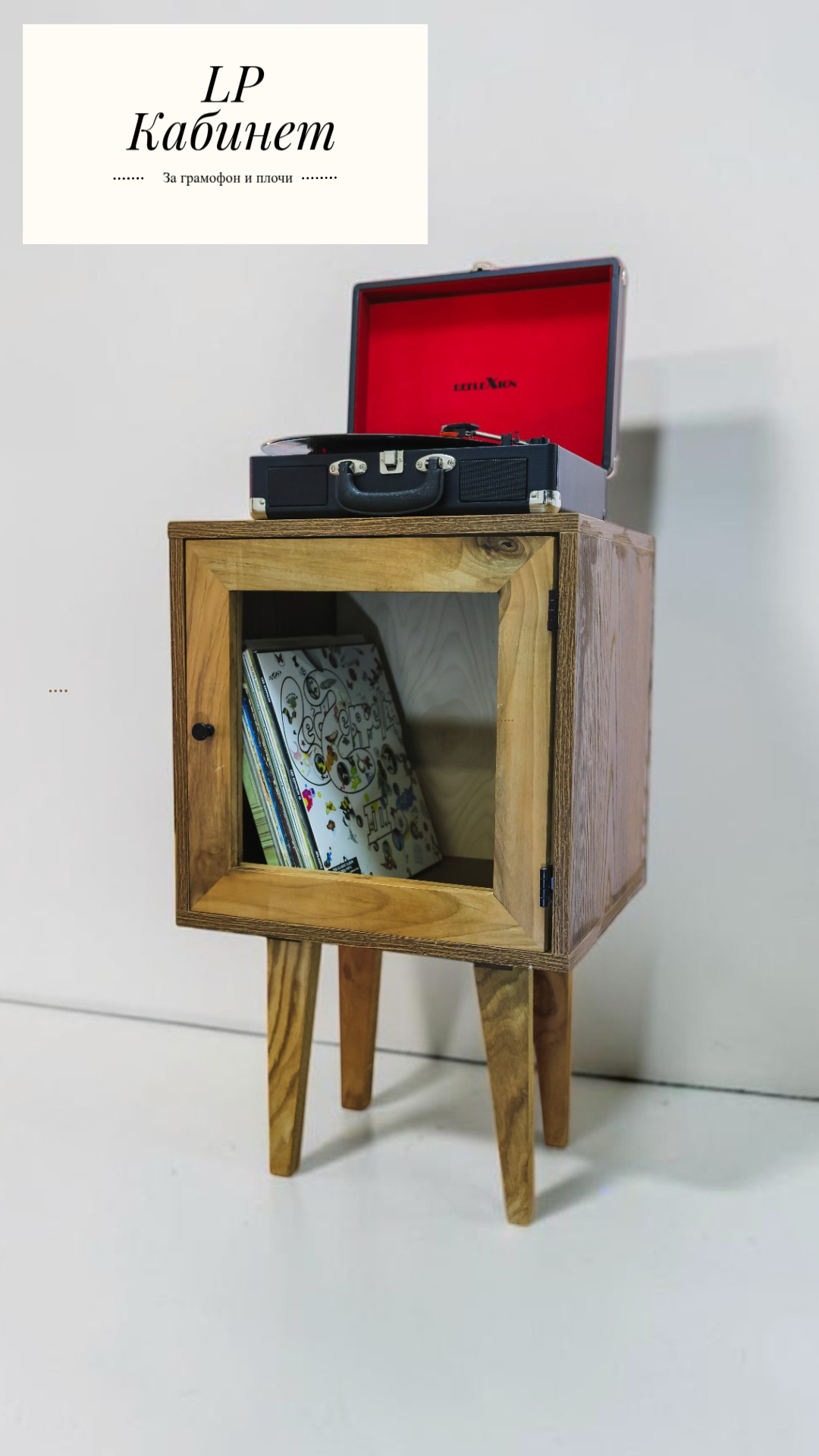 Wooden cabinet on legs with an open square front, containing magazines inside and a vinyl turntable case with a red interior on top.